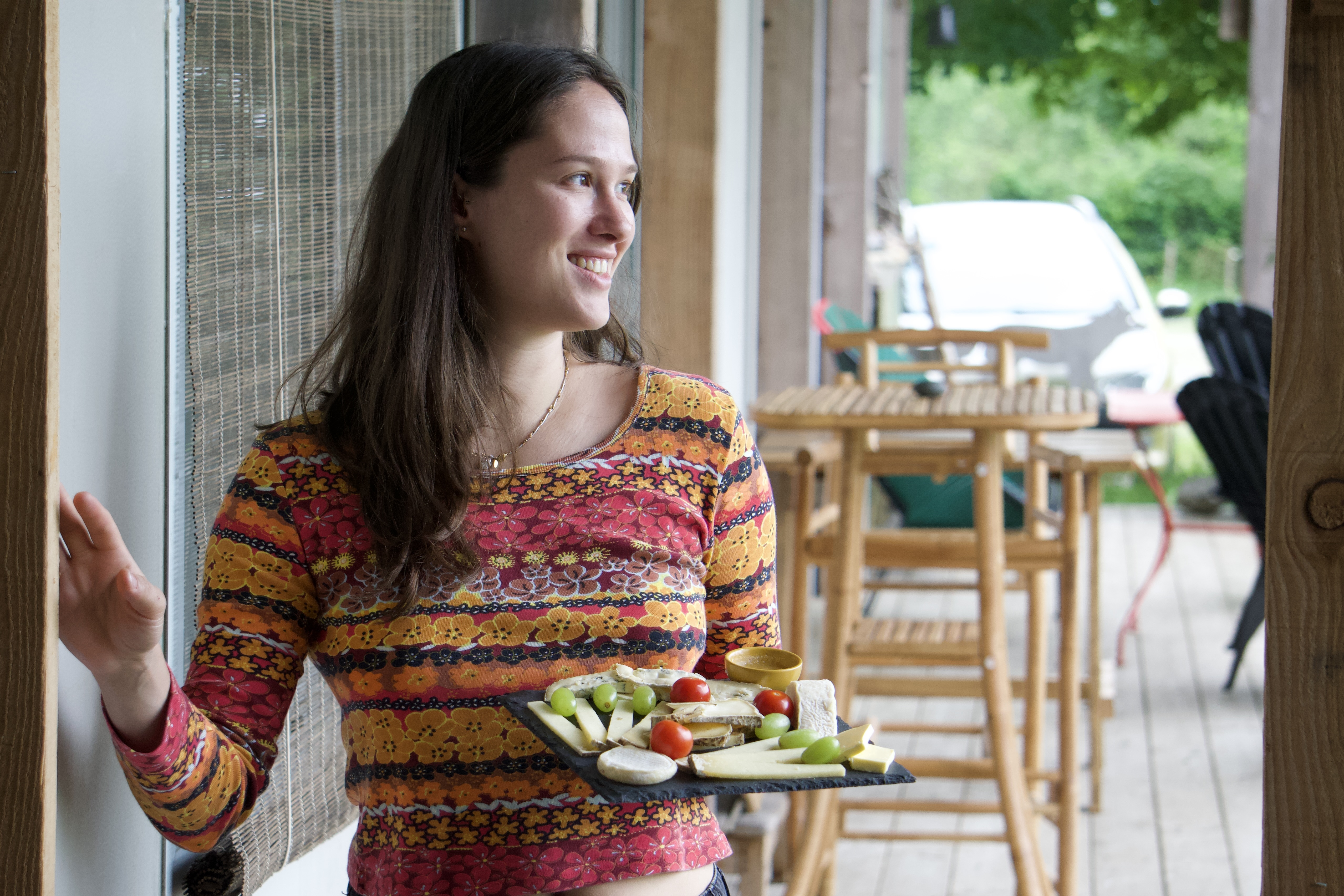 Fille qui sert une planche de fromage aux maisons de coline