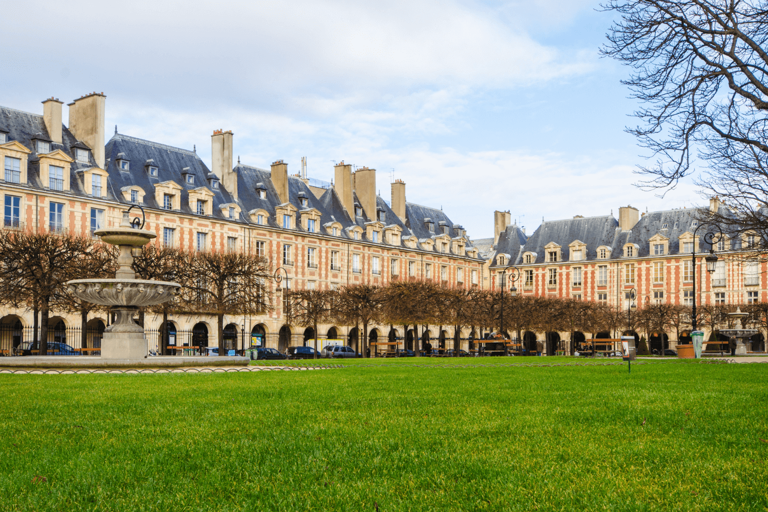 Place des Vosges, the oldest planned square in Paris, located in the heart of Le Marais, featuring its iconic red-brick facades, symmetrical architecture, and serene garden setting.