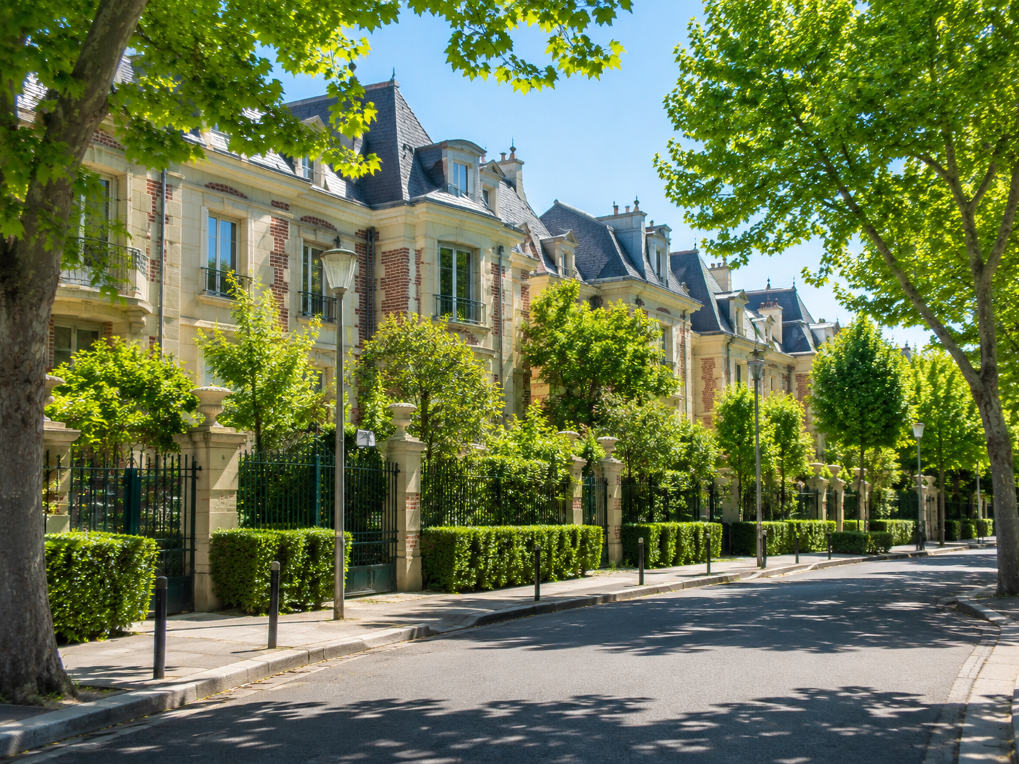 Tree-lined residential street in Neuilly-sur-Seine with elegant houses, green hedges, and classic French architecture.